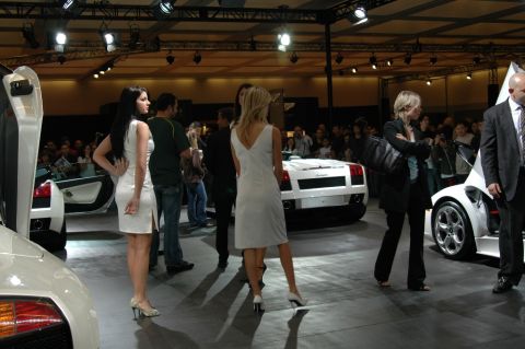 1991 Ford Taurus - Several white Lamborghinis are showcased at an indoor event with attendees observing.