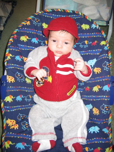 2002 Ford Taurus - A baby is dressed in a red hat and a red and gray jacket with 'Junior Racer' written on it.