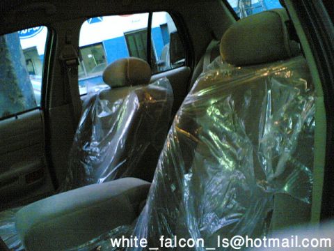 1999 Mercury Grand Marquis - Car interior with seats covered in plastic, seen through the rear windows.