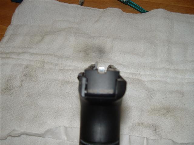 Pistol slide and rear sight on a white towel