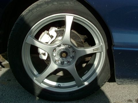 1995 Ford Probe - Close-up of a car's wheel and brake assembly, showing an aftermarket wheel and white caliper.