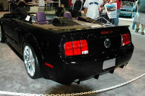 1991 Ford Taurus - This black convertible sports car has a distinctive rear design with custom wheels and an aftermarket exhaust system.