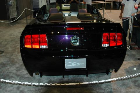1991 Ford Taurus - This black convertible features distinctive triple taillights and a custom license plate frame, likely from the mid-2000s.