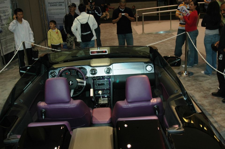 Interior view of a black convertible with purple seats and dashboard