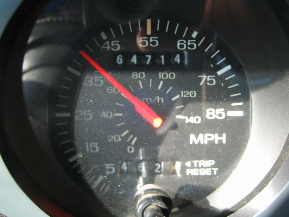 Close-up of a vehicle speedometer reading with odometer at 64714 miles