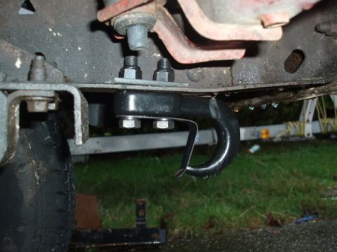 1985 Ford Bronco II - Close-up of a vehicle's frame showing a bolted-on tow hook and part of a tire.
