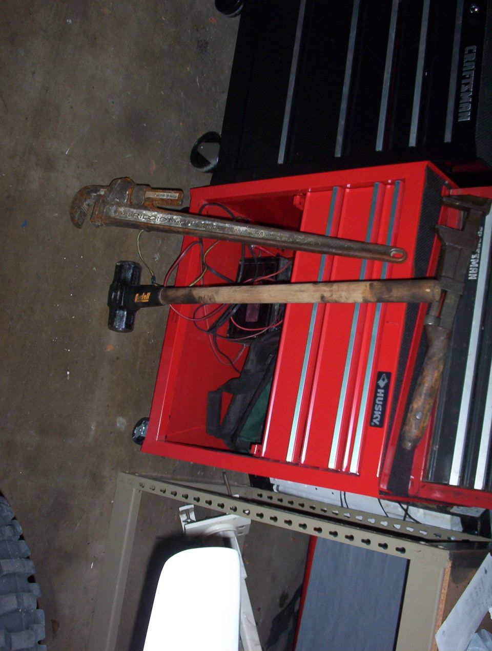 Red Husky toolbox with pipe wrench and sledgehammer