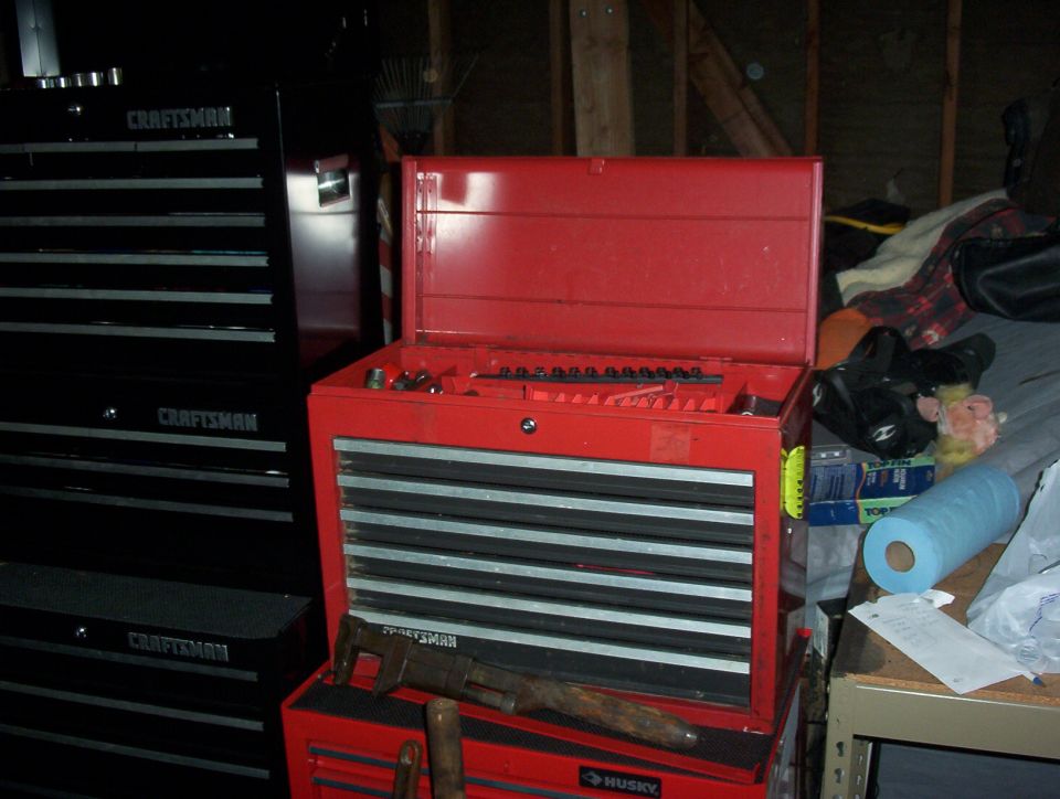 Two Craftsman toolboxes, one red and open, with tools inside and a large wrench on top