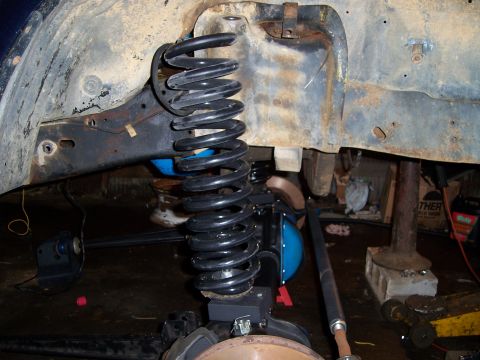 1983 Ford Bronco - Underneath view of a vehicle's suspension system, highlighting the coil spring and frame.