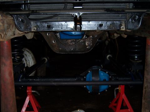 1983 Ford Bronco - The vehicle's rear axle and differential are visible, supported by jack stands during maintenance.