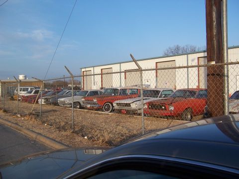 1979 Ford Ranchero - A line of older vehicles are parked outside a commercial building under a clear sky.