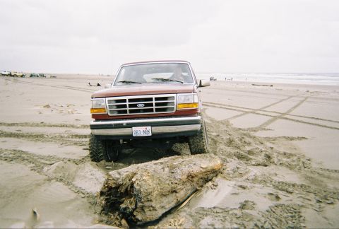 1992 Ford Bronco - This 1992 Ford Bronco navigates a sandy beach, its front grille clearly visible.