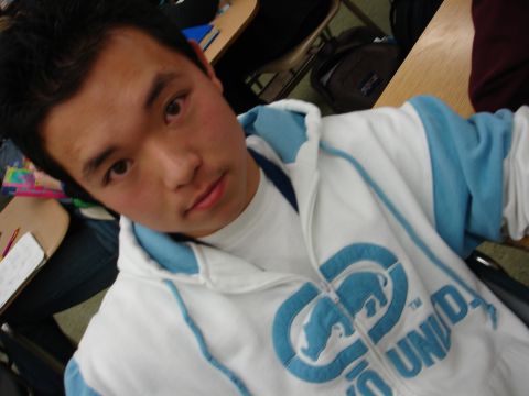 1993 Ford Taurus - A person in a classroom setting wears a white hooded sweatshirt with blue accents and a prominent circular logo.