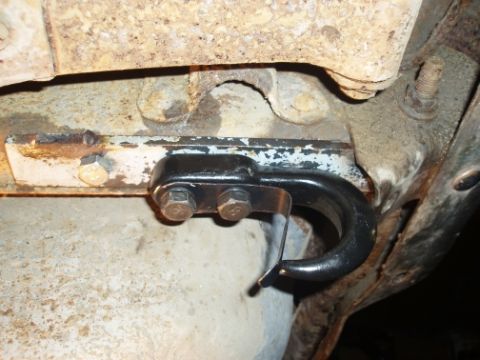 1985 Ford Bronco II - Close-up of a black tow hook attached to a white bracket on the underside of a 1985 Ford Bronco II.