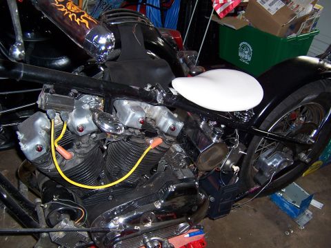 1979 Ford Ranchero - The engine of a custom motorcycle is shown with its V-twin cylinders and yellow spark plug wires.