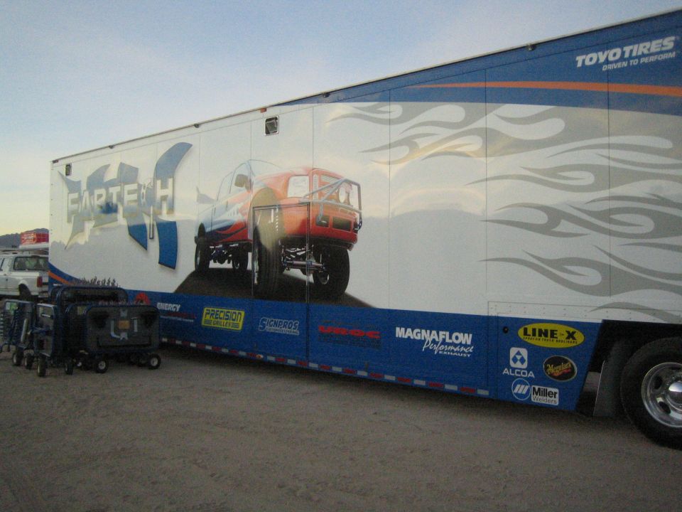 Large enclosed race trailer with Fabtech, Toyo Tires, and sponsor graphics