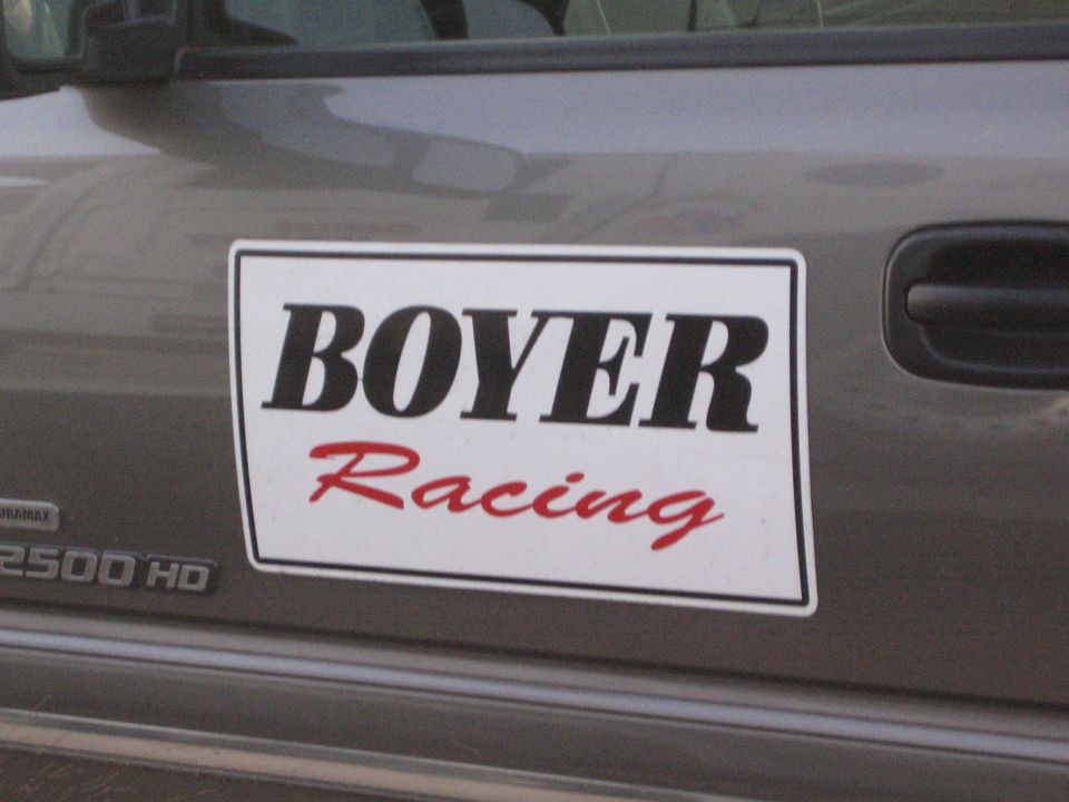 Door of a gray Duramax 2500 HD truck with a white BOYER Racing magnetic sign