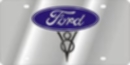 1991 Ford LTD Crown Victoria - A small brushed-metal novelty license plate with the blue Ford oval logo at the top and a chrome V8 emblem below it. The plate has a black…