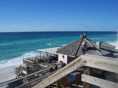 1995 Ford Bronco - A scenic view of a beach pier overlooking the ocean, with a building and people enjoying the day.