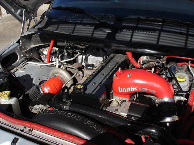 Diesel engine bay with red Banks High-Ram intake manifold, red intercooler piping and turbo plumbing