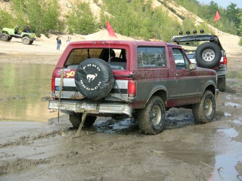 1995 Ford Bronco - This 1995 Ford Bronco is navigating a muddy off-road course, with a spare tire mounted on the rear.