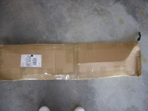 1999 Ford Taurus - A cardboard box with a shipping label sits on a concrete surface.