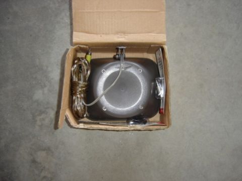 1999 Ford Taurus - A car part, possibly a sensor or light, is shown inside its original cardboard packaging.