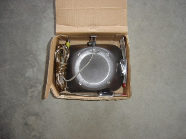 Car part in cardboard box with wires and a red-tipped probe