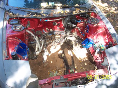 1995 Ford Probe - The engine bay of a car is shown with many components removed, revealing the internal structure and wiring.
