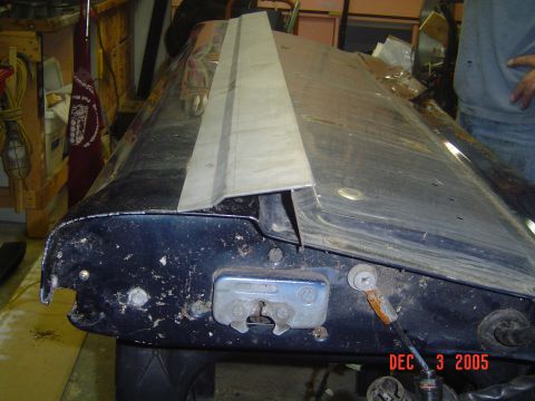 1993 Ford Bronco - Close-up view of a tailgate latch mechanism on a dark blue vehicle part, showing wear and tear.