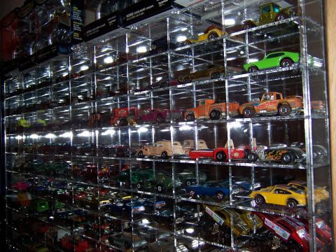 1979 Ford Ranchero - A large collection of toy cars is neatly organized and displayed on shelves within a clear case.