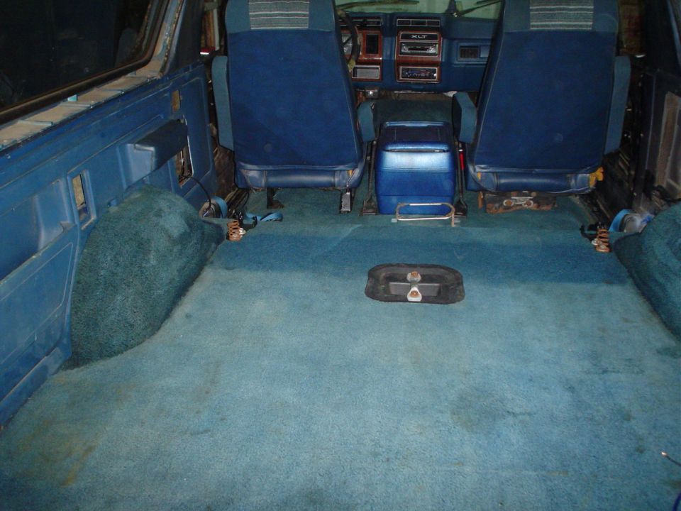 Blue carpeted interior of a vehicle with blue seats and a blue center console