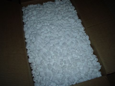 1984 Ford Bronco - A cardboard box is filled with white, peanut-shaped packing materials.
