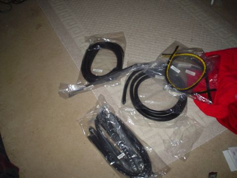 1984 Ford Bronco - New weatherstripping parts are laid out on a carpeted floor, ready for installation.