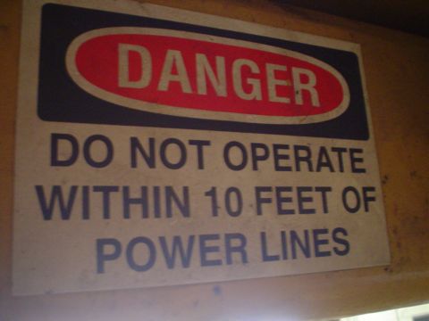 1966 International School Bus - A danger sign warns about operating equipment near power lines.