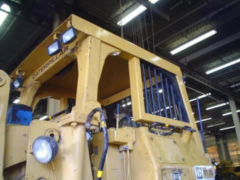 1966 International School Bus - Close-up view of the cab of a yellow Caterpillar construction vehicle, showing the CATERPILLAR branding.