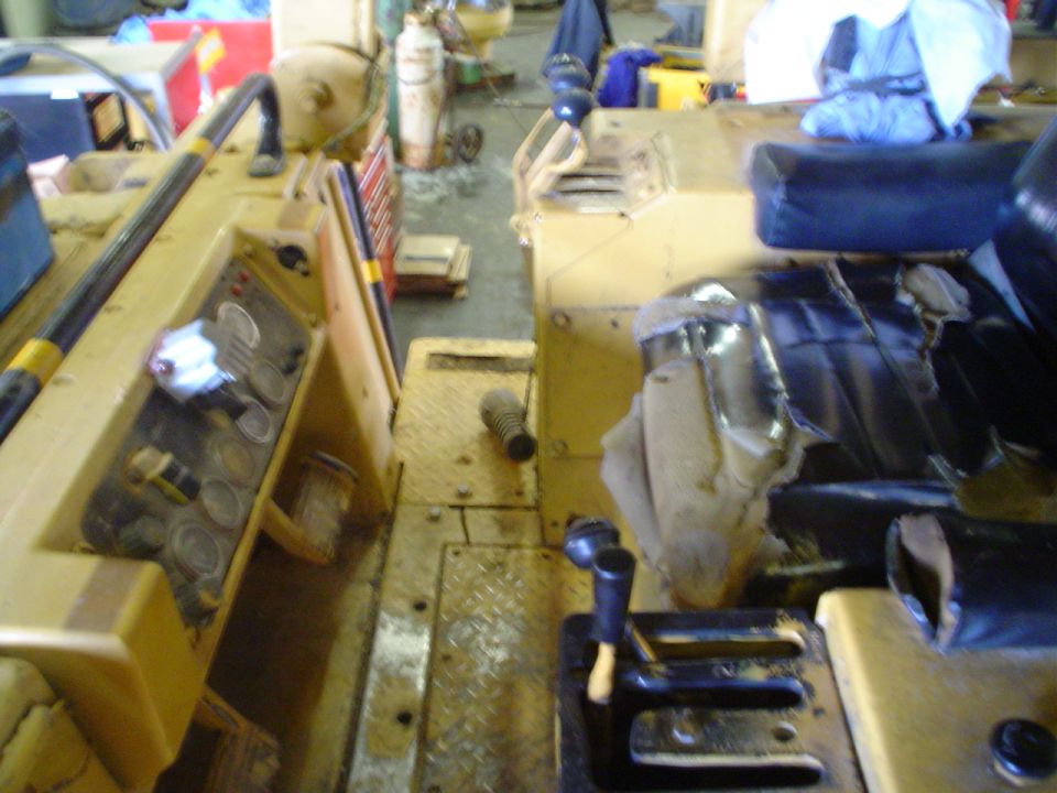 Interior view of a yellow vehicle's dashboard and seats, showing gauges and controls