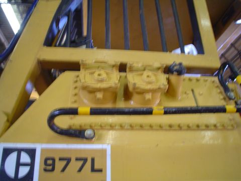 1966 International School Bus - Close-up view of the side of a yellow Caterpillar 977L loader, showing some of its mechanical components.