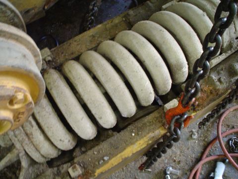 1966 International School Bus - Close-up of large, industrial suspension springs secured by heavy chains.