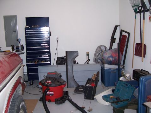 1978 Ford Bronco - Garage scene with various tools, vehicle parts, and a partial view of a vehicle.