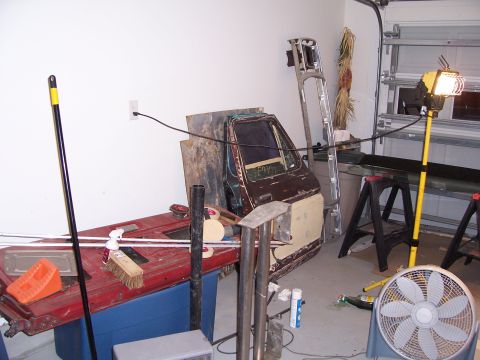 1978 Ford Bronco - A car door and frame are visible in a cluttered garage setting.