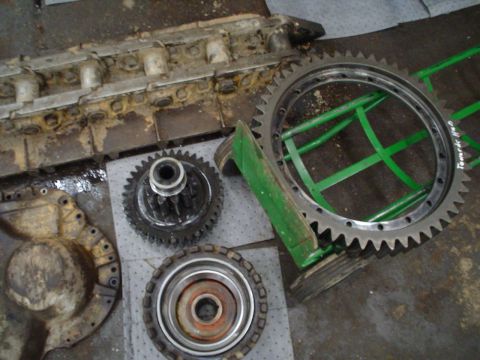 1966 International School Bus - Disassembled engine components and gears are laid out on a surface, with some parts resting on green supports.