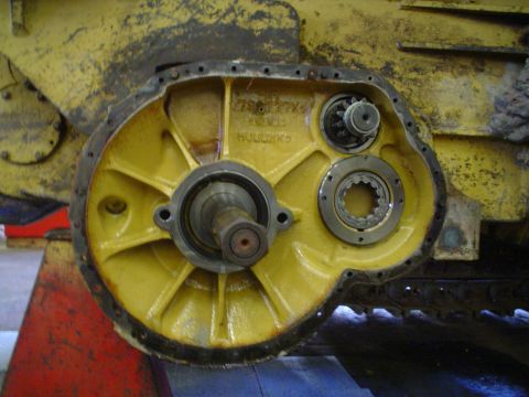 1966 International School Bus - Close-up view of a yellow internal gearing mechanism, possibly from heavy machinery, with visible text 'HOODBK5'.