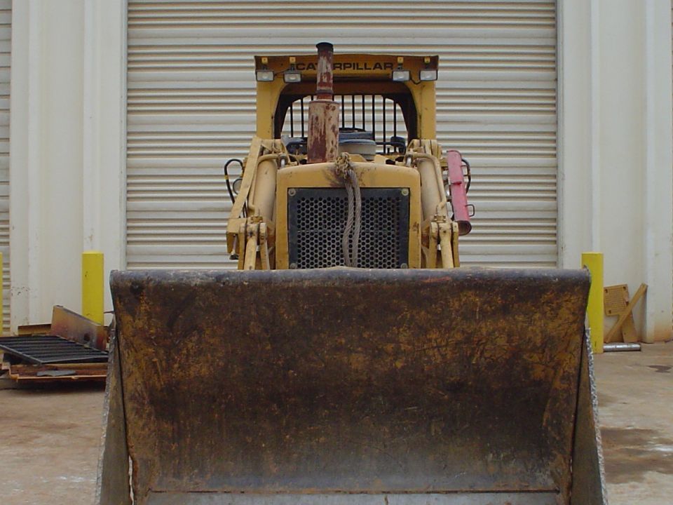 Yellow bulldozer with a large front blade, facing forward. Text 'CATERPILLAR' is visible above the cab