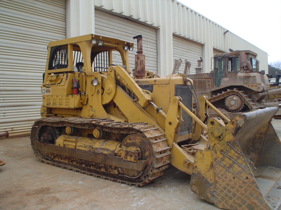 Yellow Caterpillar bulldozer with a front loader, parked next to another bulldozer