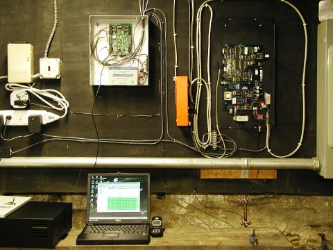 1992 Ford Taurus - Electrical control panels and a laptop are set up on a workbench against a dark wall.