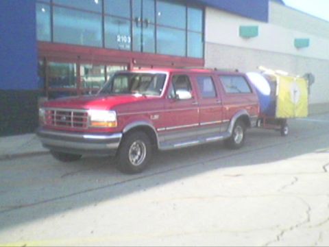 1994 Ford C-150 (Centurion Conversions) - Red 1994 Ford C-150 Centurion Conversions pickup truck is seen from the front-three-quarter angle.