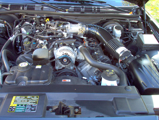Clean engine bay of a Ford Crown Victoria showing V8 engine, alternator, intake duct, and reservoirs