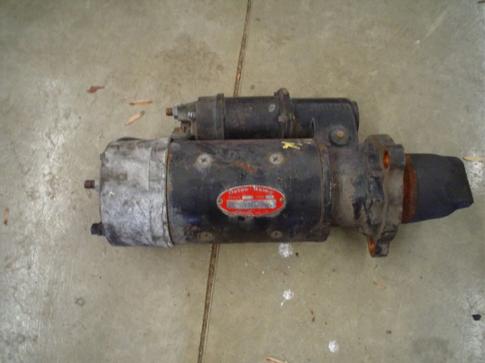 Delco-Remy heavy-duty starter motor with red ID tag lying on a concrete floor