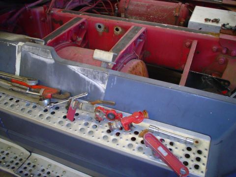 1966 International School Bus - Tools are laid out on the steps of a truck chassis, possibly for maintenance or repair.
